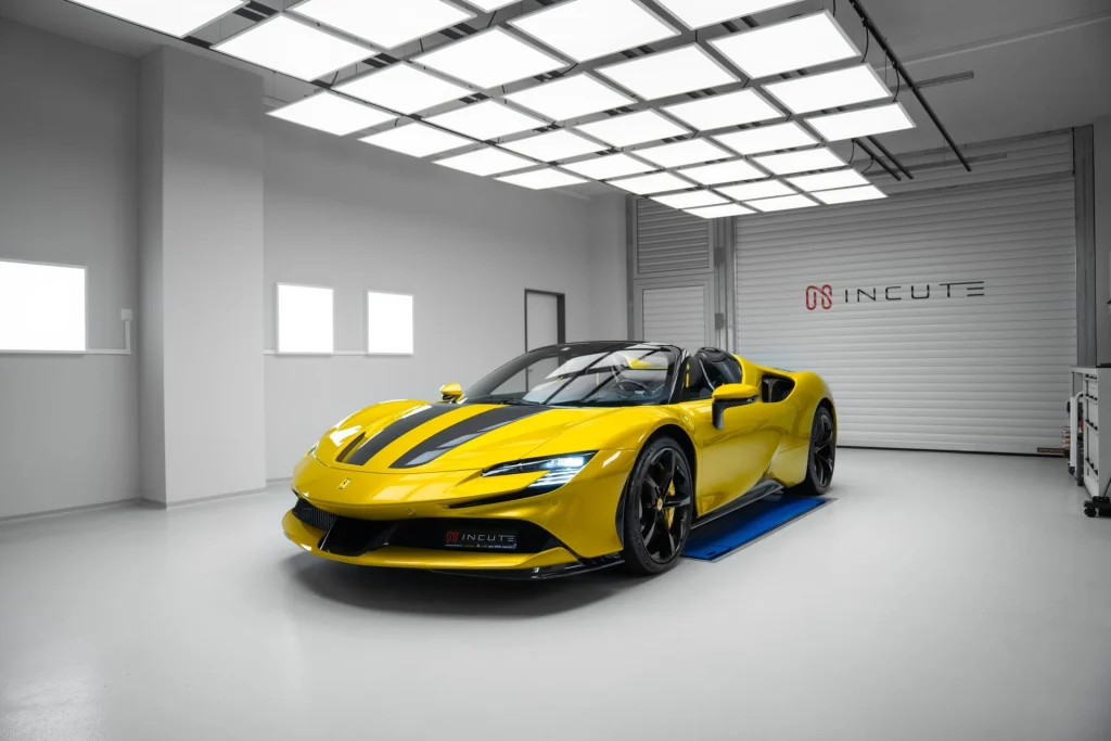 Yellow Ferrari SF90 Spider with black bonnet stripes in the INCUTE studio under a grid of LED lights